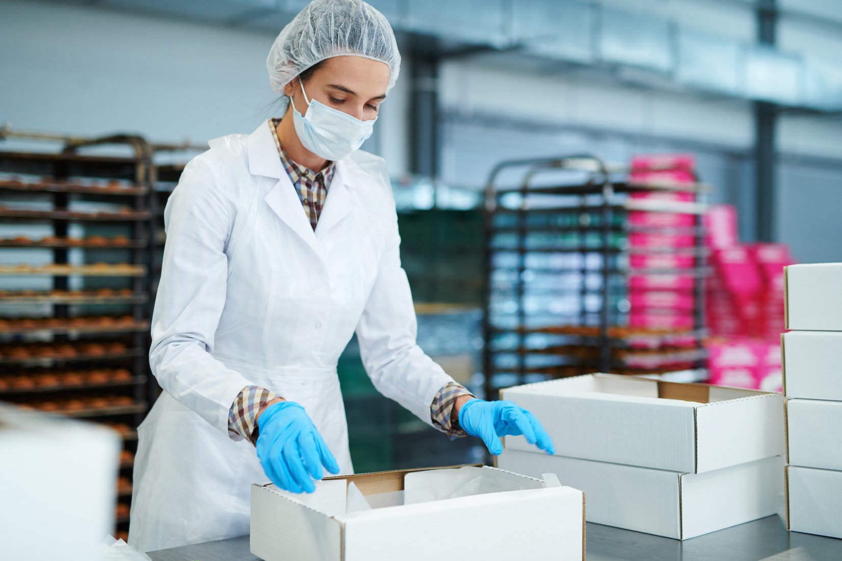 Confectionery factory worker preparing package